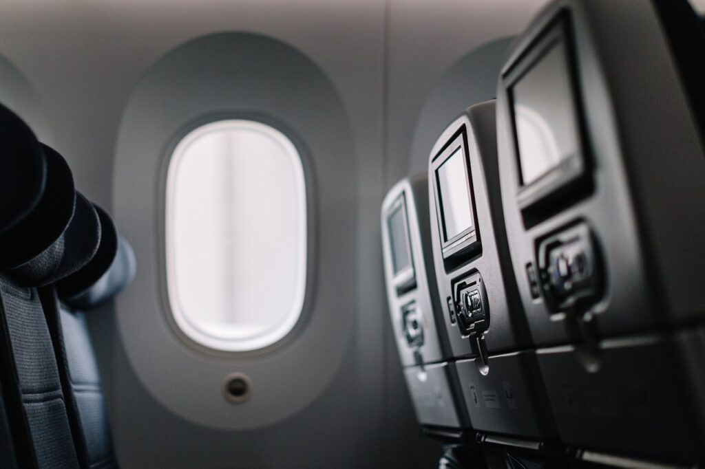 image of the interior of a plane showing seats and a window